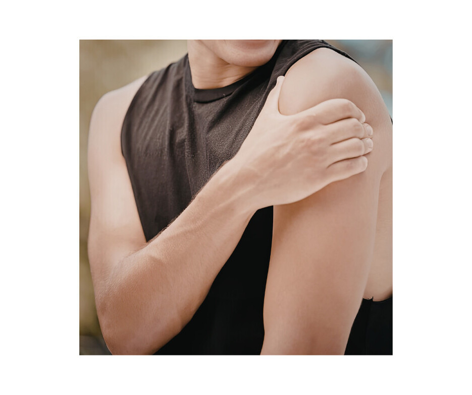 Person experiencing shoulder pain and holding their upper arm and shoulder